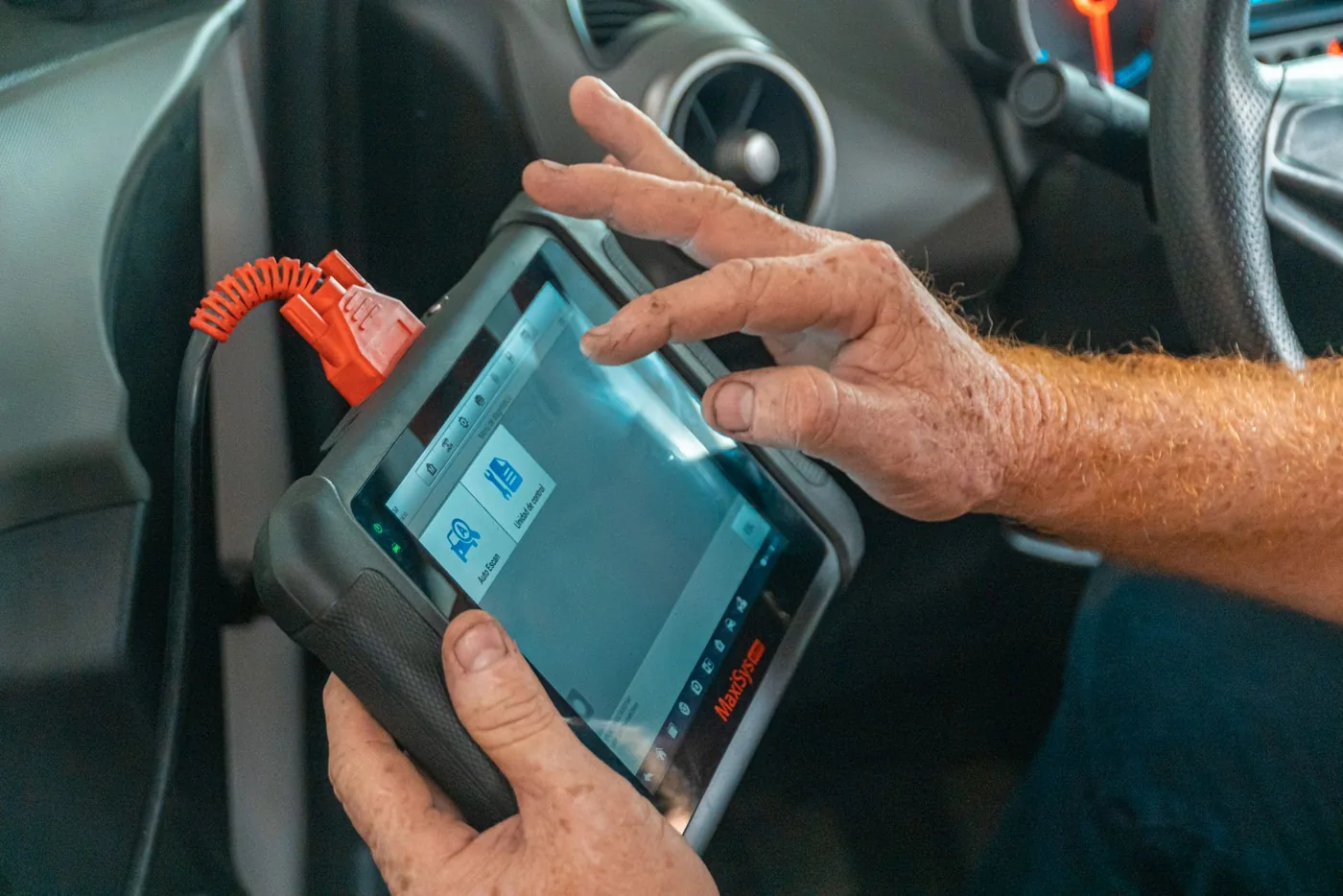 Mechaniker nutzt ein Diagnosegerät in einer Fahrzeugwerkstatt, illustratives Stockfoto